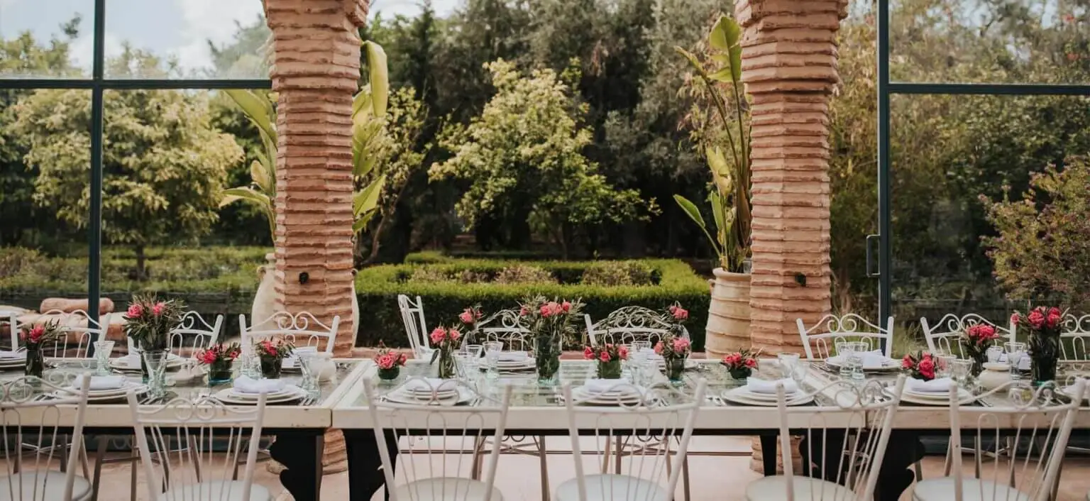Outdoor dining setup with floral arrangements and garden view.